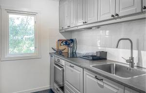 a white kitchen with a sink and a window at Nice Home In Gotlands Tofta With Wifi 