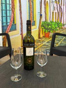 a bottle of wine sitting on a table with two wine glasses at Loft Alegría de Jerez in Jerez de la Frontera