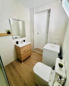 a bathroom with a toilet and a sink and a mirror at Loft Alegría de Jerez in Jerez de la Frontera +17 photos