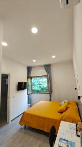 a bedroom with a yellow bed and a window at Swallow Room Holidays in Massa Lubrense