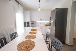 a kitchen with a table with chairs and a refrigerator at Aegean Nest I Seaside 3 bedroom Apartment in Alexandroupolis in Alexandroupoli