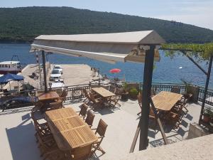 a patio with tables and chairs next to the water at Apartments Grispolis in Tivat