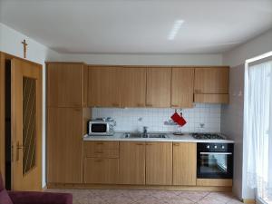 een keuken met houten kasten en een magnetron bij Appartamenti Villa Maria in Canazei +8 foto's