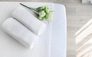 two towels on a white table with flowers on it at ICON Urban Living in Thessaloniki