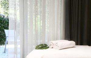 a bed with towels on it in front of a window at ICON Urban Living in Thessaloniki