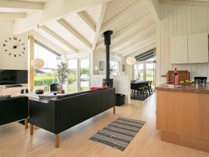 a kitchen and living room with a clock on the wall at 6 person holiday home in Hirtshals in Hirtshals