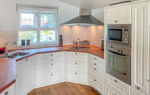 a kitchen with white cabinets and a sink and a microwave at 3 Bedroom Amazing Home In Workum in Workum