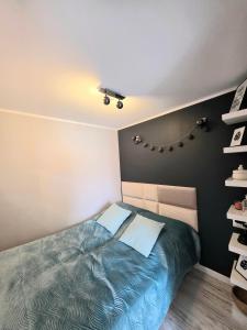a bedroom with a bed with a blue comforter at Apartament Z Widokiem Na Wieżę in Wałbrzych