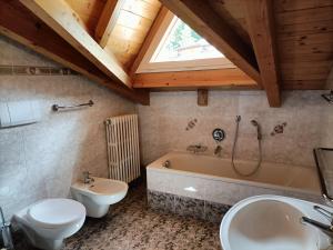 een badkamer met toilet, bad en wastafel bij Appartamenti Villa Maria in Canazei