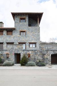 ein Steingebäude mit Fenstern an der Seite in der Unterkunft CASA GAVIN l Torreon l Terraza l Wifi l Vistas in Biescas