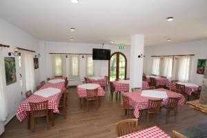 a dining room with red and white tables and chairs at Vila Dr Bizhga Agroturizem 