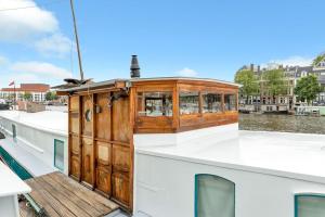a wooden cabin on the back of a boat at Woonboot - Houseboat Amsterdam in Amsterdam