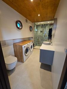 a bathroom with a washing machine and a washer at Woonboot - Houseboat Amsterdam in Amsterdam