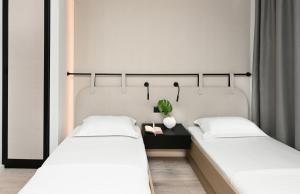 a bedroom with two beds and a plant on a table at ICON Urban Living in Thessaloniki