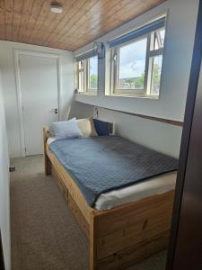 a bed in a small room with a window at Woonboot - Houseboat Amsterdam in Amsterdam