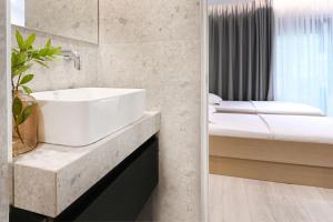 a bathroom with a white sink and a bed at ICON Urban Living in Thessaloniki +45 photos