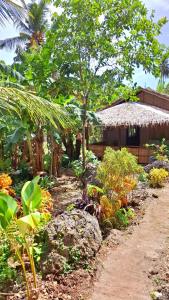 ein Garten vor einem Haus mit Strohdach in der Unterkunft Goofy Surf House in Burgos