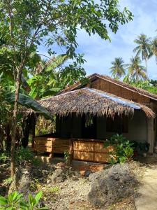 ein kleines Haus mit Strohdach in der Unterkunft Goofy Surf House in Burgos + 11 Fotos