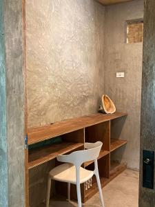 ein weißer Stuhl neben einem Holzregal in der Unterkunft Goofy Surf House in Burgos