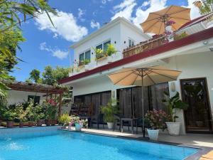 a villa with a swimming pool and a house at Moalboal LRS Lovers Nest in Basdiot