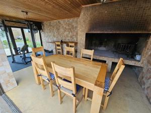 a wooden table and chairs and a fireplace at Ocean Glimpse in Cape Town