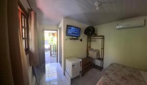 a room with a tv on the wall and a room at Recanto Casa Amarela de São Romão in Nova Friburgo