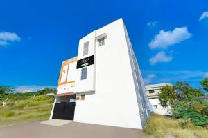 a white building with a sign on the side of it at Collection O Neelambur Near PSG ITech in Irugūr