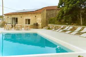a pool in front of a stone house at Reverence Villas Avieira in Carballal