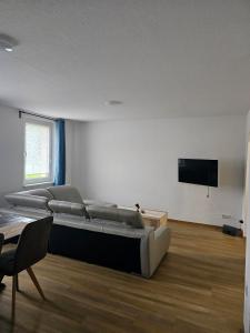 a living room with a couch and a flat screen tv at Monteurs- & Gästewohnungen nähe Raffinerie Leuna & Geiseltalsee für 4Personen in Frankleben