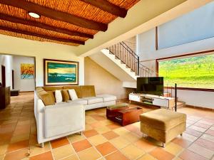 a living room with a couch and a tv at Rivera Campestre in Tinjacá