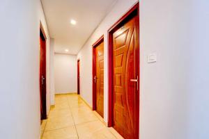 a hallway with two wooden doors and a tile floor at Collection O Pukkattupady Aluva East in Kakkanad