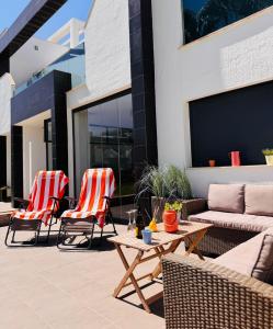 a patio with two chairs and a couch and a table at Viva La Zenia in Orihuela Costa