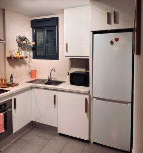 a kitchen with white cabinets and a refrigerator at Viva La Zenia in Orihuela Costa