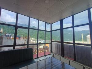 una habitación con una habitación grande con una ventana grande en The Mountain View Tapovan, en Narendranagar