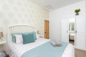 a bedroom with a bed with blue and white pillows at Calder Row by Alt-Stay Contractor Accommodation - 3 Bed Canal Side Contractor Home With Parking, Wi-Fi & Full Kitchen - Ideal For Long stays in Wakefield