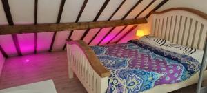 a bedroom with a bed in a room with pink lighting at First and Last Youth Hostel in Dover