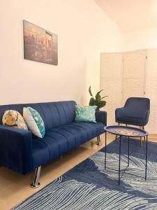 a blue couch in a living room with a table at Boutique Studio , Guest Suit , AJMAN in Ajman 