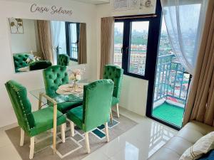a dining room with a table and green chairs at FREE Parking City lights AlexaVoice Control Unit in Manila