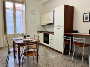 a kitchen with a wooden table and chairs and a table and a tablektop at Casa del Grillo in Messina
