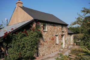 an old stone house with flowers on it at The Little Welsh Cottage in Brynmenin +16 photos