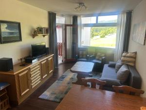 a living room with a couch and a tv at Kurhotel Schluchsee Apartment 1305 in Schluchsee