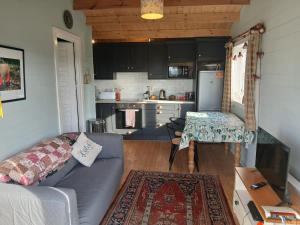 a living room with a couch and a kitchen at Caherhurley Cabin in Tuamgraney