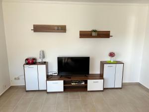 a living room with a television and white cabinets at Ferienwohnungen am Wald in Lütow