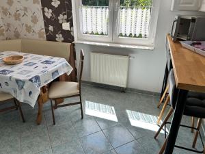 a kitchen with a table and chairs and a table and windows at Ferienwohnungen am Wald in Lütow
