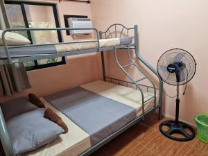 a bunk bed with a fan in a room at 3 Bedrooms 2 storey House in Dipolog