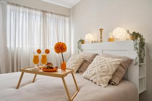 Un dormitorio con una cama con una mesa con un bol de fruta encima. en " La Casa verde " Superbe T3, chic & cosy avec climatisation en hypercentre, en Villeurbanne