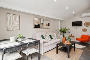 una sala de estar con un sofá y una mesa en " La Casa verde " Superbe T3, chic & cosy avec climatisation en hypercentre, en Villeurbanne