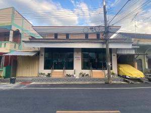 a building with a yellow covering on the front of it at Farwa home in Kampong Rusamileh