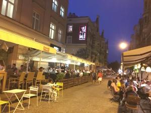 una multitud de personas sentadas fuera de un restaurante por la noche en Elegant Apartment Foksal, en Varsovia