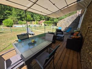 un patio avec une table et des chaises sur une terrasse dans l'établissement Gîtes Le Carpe Diem, Cottage Le Petit Pattaris, à Frayssinet-le-Gélat